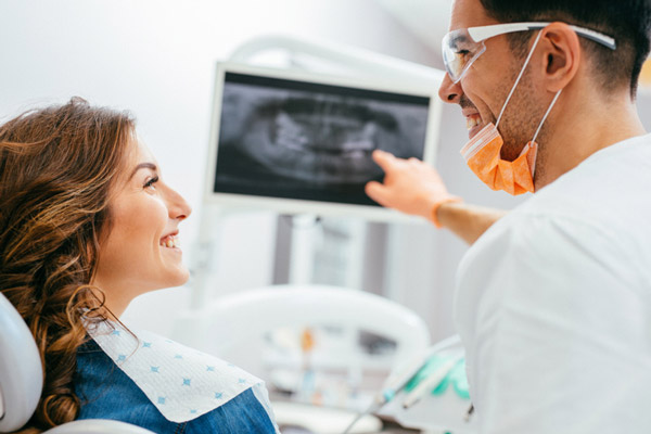 Dentist explaining an x-ray to a woman patient, at United Smile Centres in Louisville, KY.