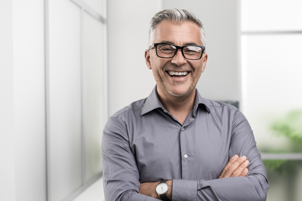 Man smiling with his arms crossed.